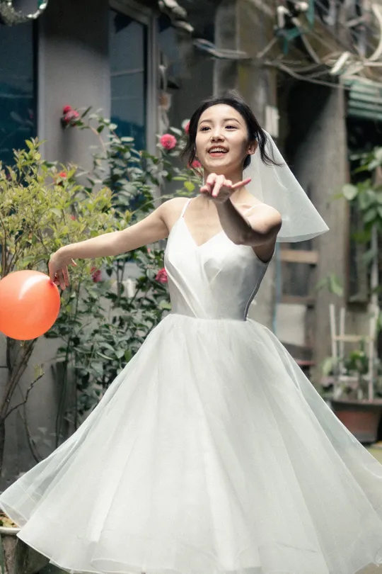 一位穿着白色连衣裙拿着气球的女士