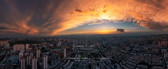 夕阳下城市的 aerial view 带有云彩