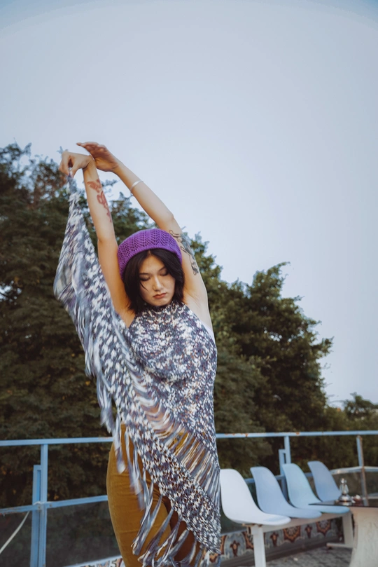 一个穿着裙子和帽子 站在滑板上的年轻女子