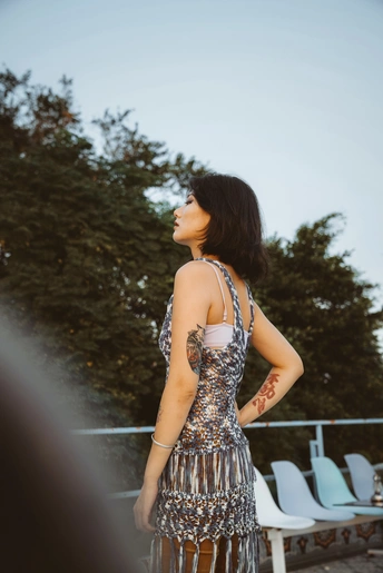 一位穿着银色连衣裙的年轻女子站在外面