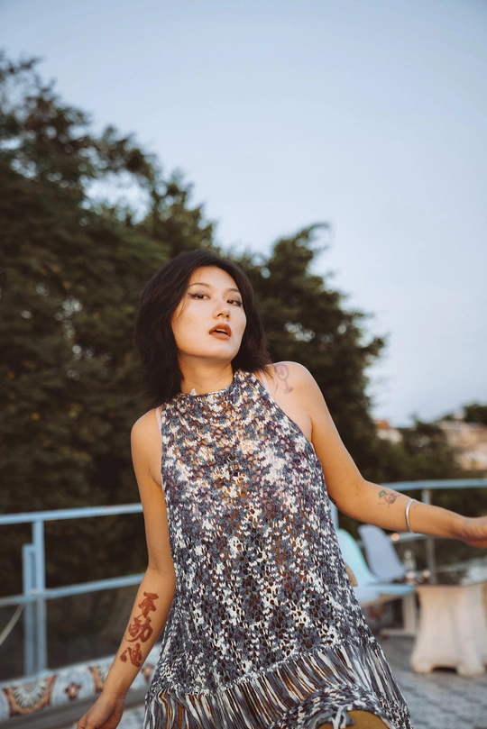 一位穿着银色连衣裙的年轻女子站在外面