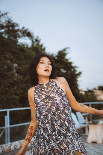 一位穿着银色连衣裙的年轻女子站在外面