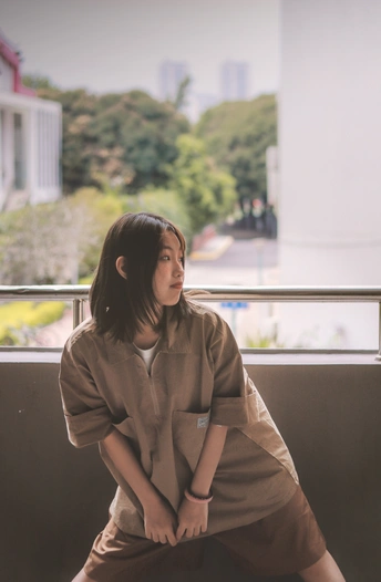 一位年轻女子坐在阳台上 在窗户前摆姿势