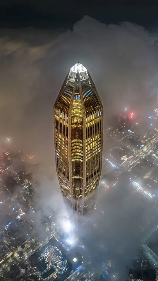 从一座雾气缭绕的城市高楼的顶部拍摄的夜晚照片