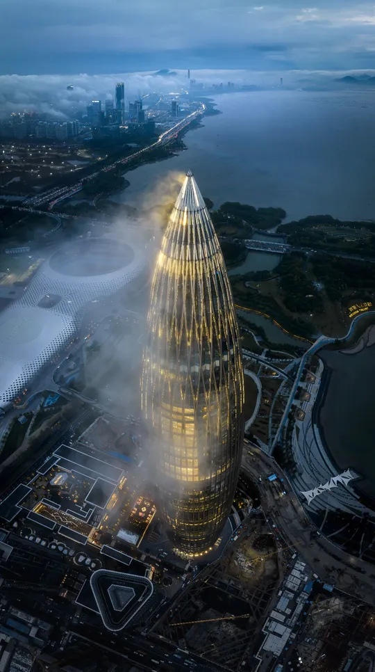 夜晚拍摄的一座雾气缭绕的城市 位于高塔顶部的一张照片。