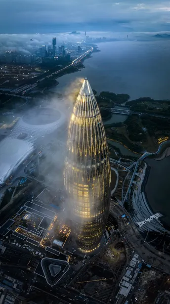 夜晚拍摄的一座雾气缭绕的城市 位于高塔顶部的一张照片。