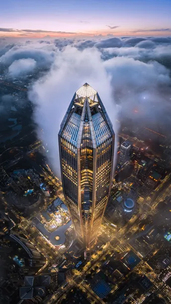 夜晚在云端和雾中一座高楼上拍摄的城市的照片