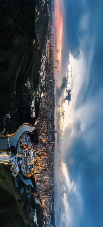 从飞机上拍摄的夜晚海岸城市的水和云的 aerial photo