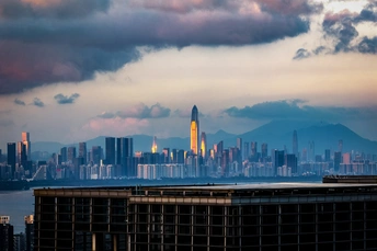 夕阳下 云雾缭绕的大城市天际线 摩天大楼 建筑和远处的山脉。