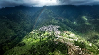 天上彩虹 山谷绿坡 城市在下方