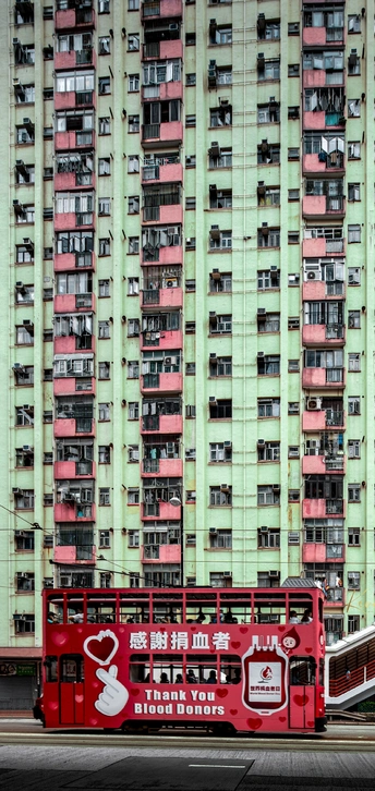 红色双层公交车驶过城市中的高楼大厦