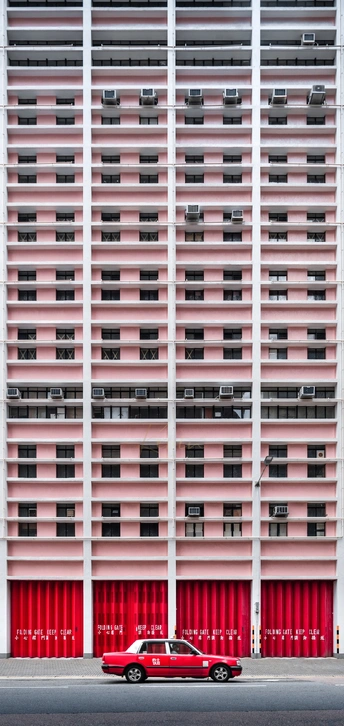 停在街道旁高楼前的红色汽车