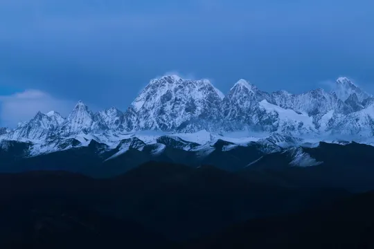暮色中照亮一座白雪皑皑的山脉