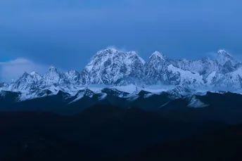 暮色中照亮一座白雪皑皑的山脉