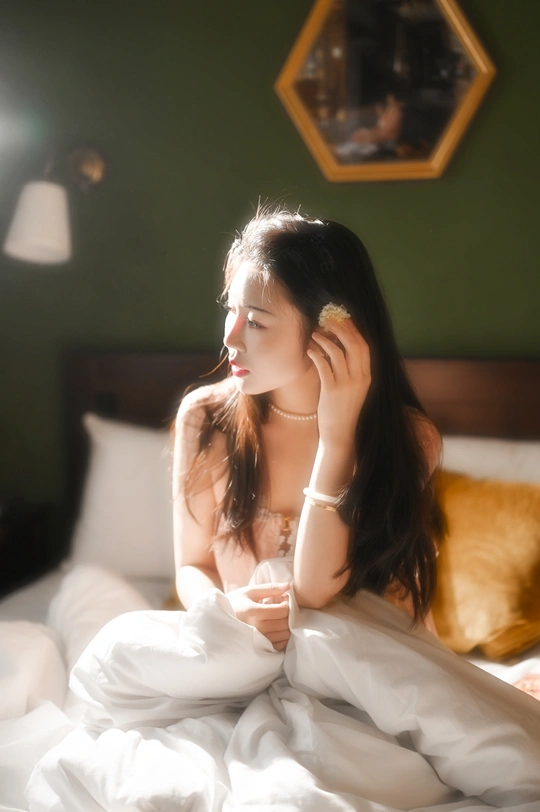 一个坐在床上喝饮料的年轻女人