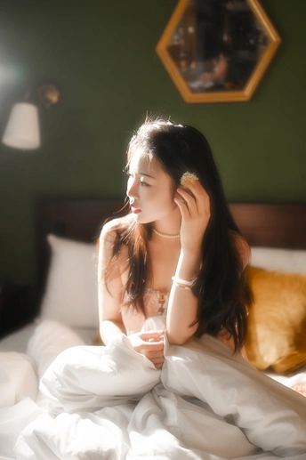 一个坐在床上喝饮料的年轻女人