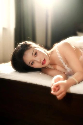 躺在白色床上的美丽的年轻女士