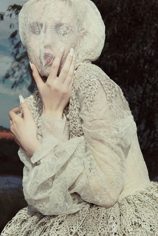 一位女士面前拿着香烟的白裙女子