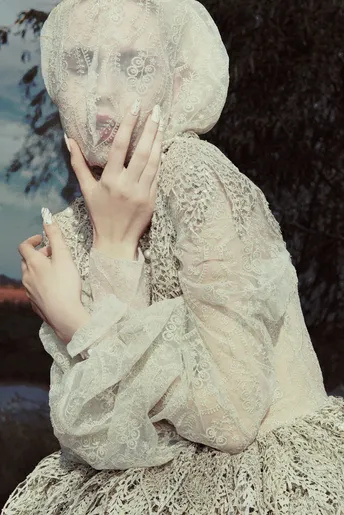 一位女士面前拿着香烟的白裙女子