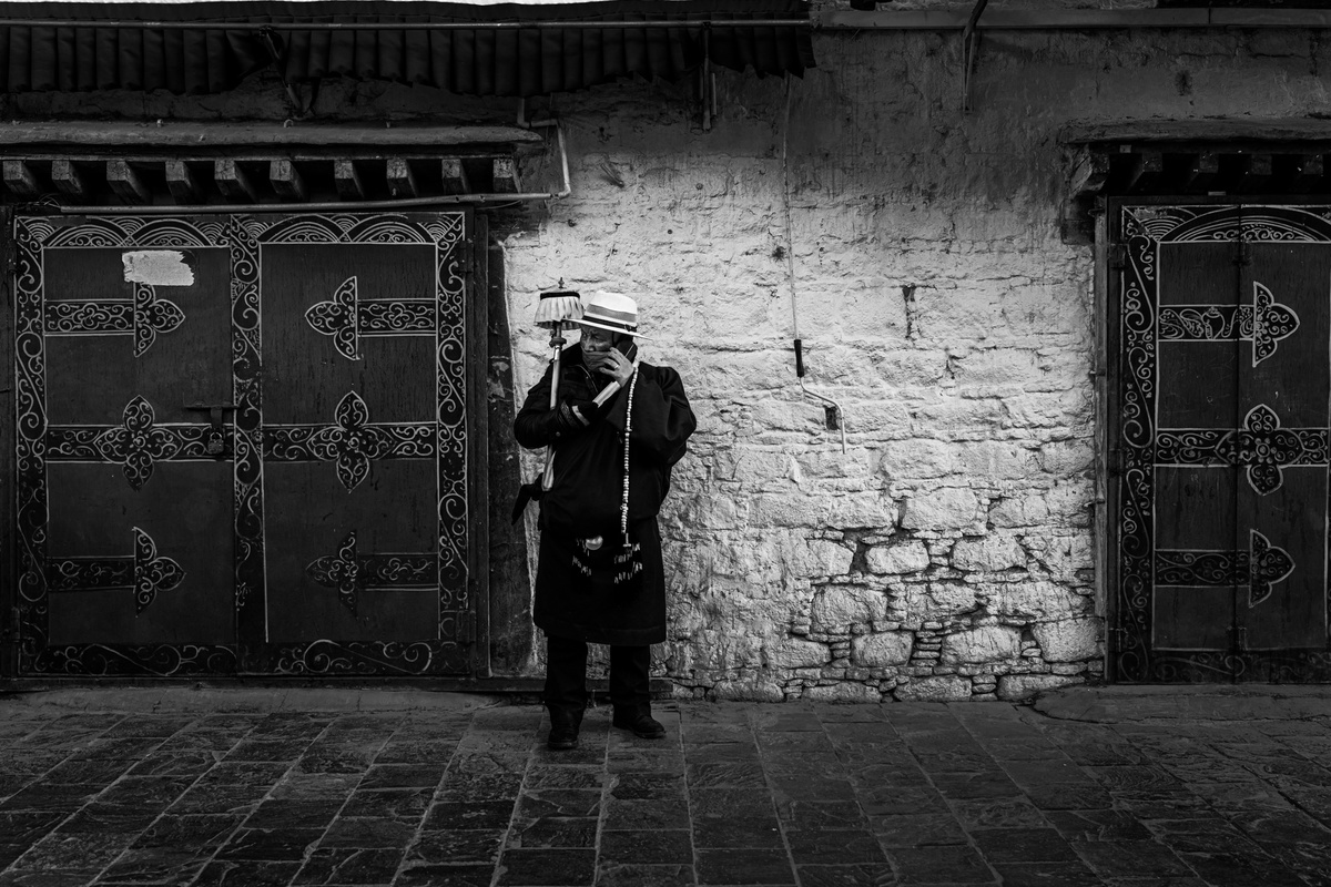 一个戴帽子的人在街上站在一栋老建筑前 黑白照片
