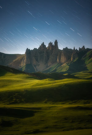 夜晚的山脉 天空中繁星闪烁 绿草如茵。