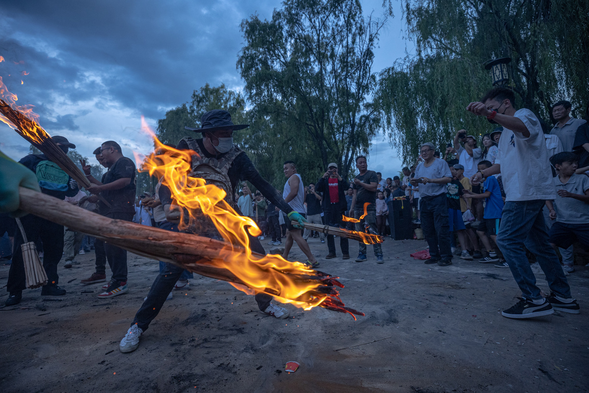 围绕着篝火的群众在跳舞 篝火中的木棍发出火焰。