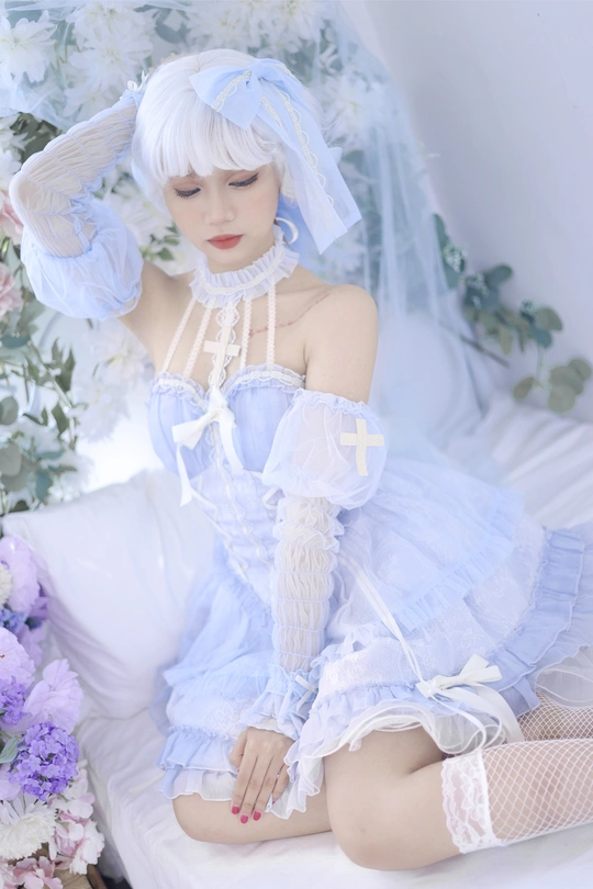 一个穿着带蓝色面纱和花朵的白色连衣裙的女人