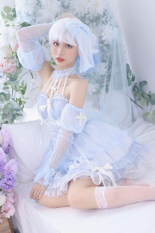 一个穿着蓝色连衣裙的白发美女坐在床上