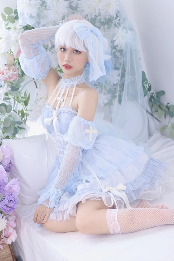 一个穿着蓝色连衣裙的白发美女坐在床上