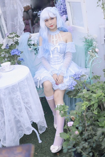 一个蓝色头发、穿着白色连衣裙的女人坐在花园里的椅子上