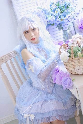 一个穿着蓝色连衣裙的白发女人坐在一篮鲜花旁边的椅子上