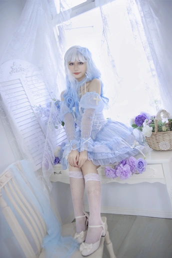 一个蓝色头发、穿着白色连衣裙的小女孩坐在椅子上