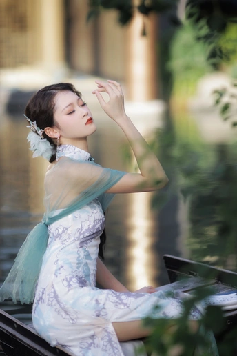 一个穿着连衣裙的美女坐在船上