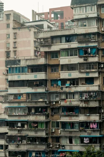 许多窗户的摩天大楼 在大城市的街道上 人们聚集在前面。