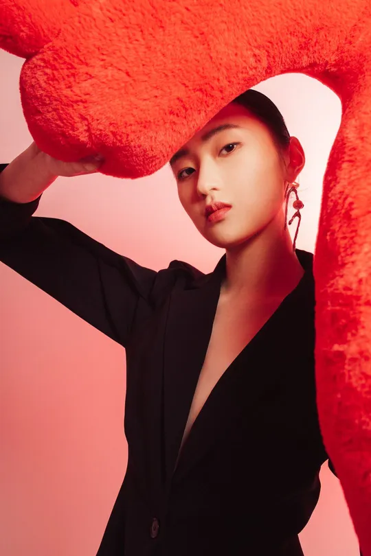 一位穿黑色衣服的女人手里拿着一颗大红色的心