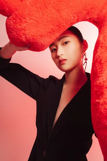 一位穿黑色衣服的女人手里拿着一颗大红色的心