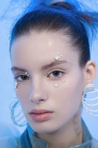 一位戴蓝发和珍珠饰品的女人