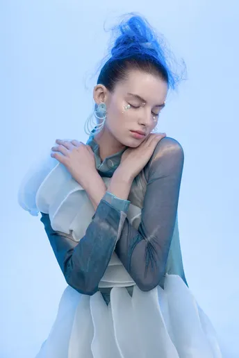 一位留着蓝色头发的年轻女子穿着白色裙子