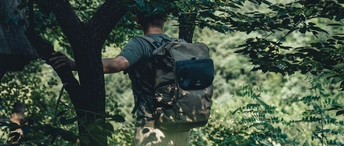 一个背着背包的男人穿过森林 里面有树。