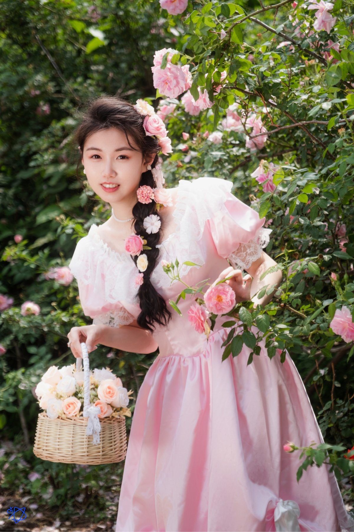 一位穿着传统裙子的年轻女子在玫瑰花丛中摆姿势 手里拿着一个花篮。