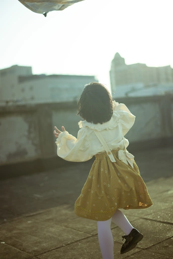屋顶上一个穿着黄色连衣裙、打着雨伞的小女孩