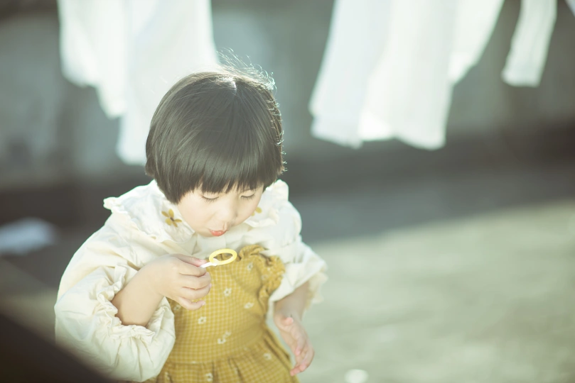 一个穿着黄色连衣裙的小女孩在玩衣服