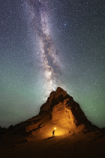 一个人站在山顶仰望夜空中星星