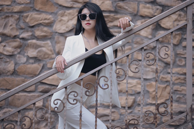 一位穿着白大褂和黑色太阳镜的年轻女子走上楼梯
