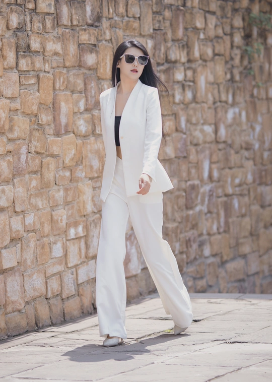 一位穿着白色西装和黑色太阳镜的女人
