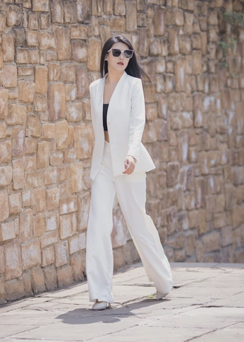 一位穿着白色西装和黑色太阳镜的女人