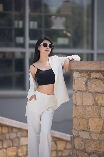 一位穿着黑色露脐上衣和白色裤子的女人