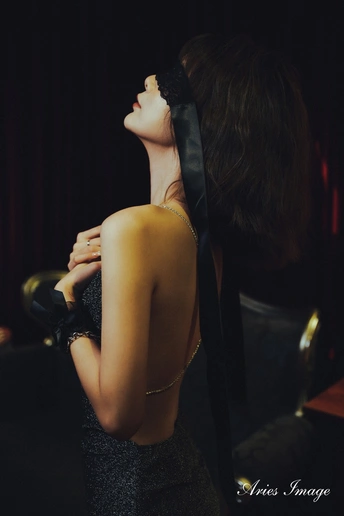 一位穿着黑色连衣裙和领带的年青女子