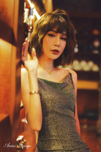 一位穿着连衣裙的年轻女子举起手来抚摸她的头发