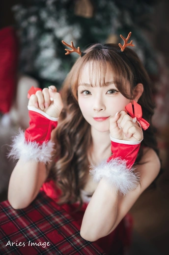 一位穿着红裙子的年轻女孩在为圣诞照片摆姿势